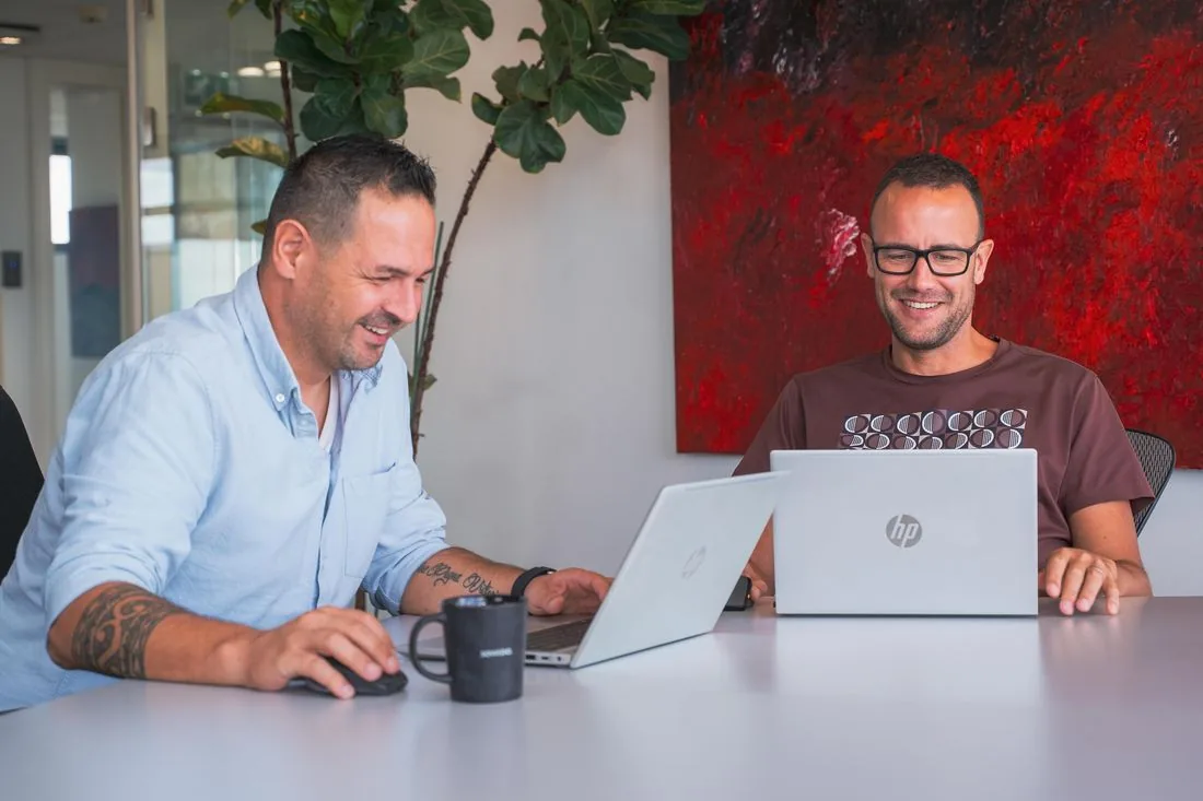 Twee SOWEDO-collega's werken samen aan een laptop